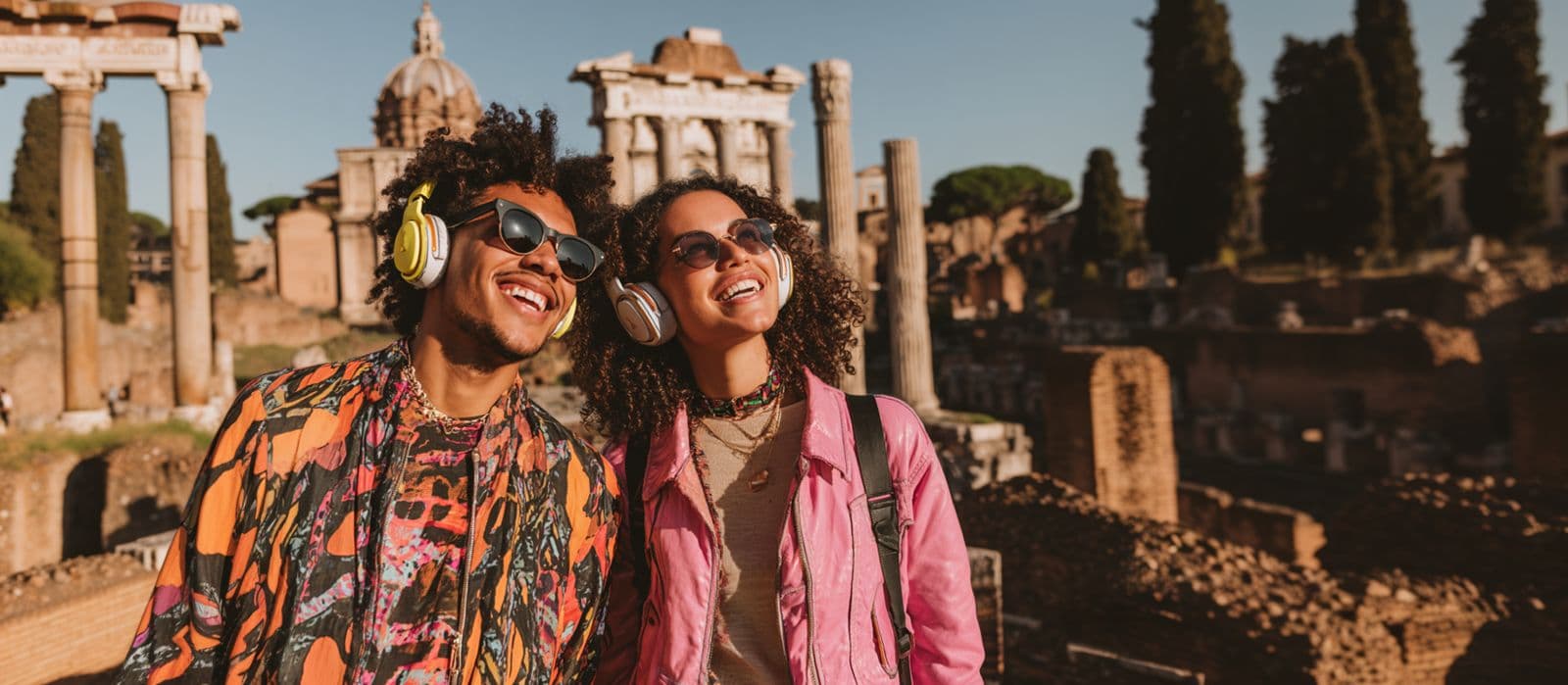 Couple with headphones exploring Roman ruins with AI audio guide
