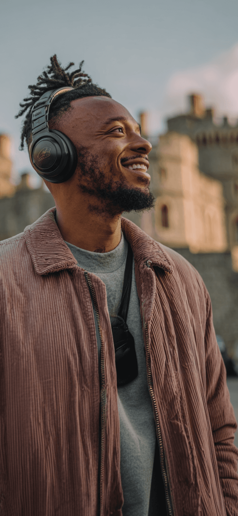 Cheerful visitor using AI audio guide at a historic castle